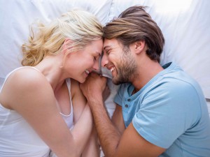 Cute couple relaxing on bed smiling at each other