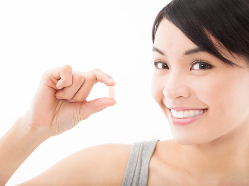 Young woman with pill