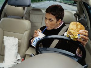 Woman driving and eating fast food