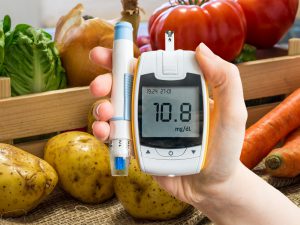Hand holds glucometer for measuring glucose level