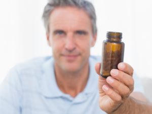 Man holding vitamin bottle