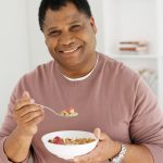 Mature man eating breakfast