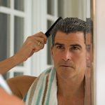 Mature man combing hair