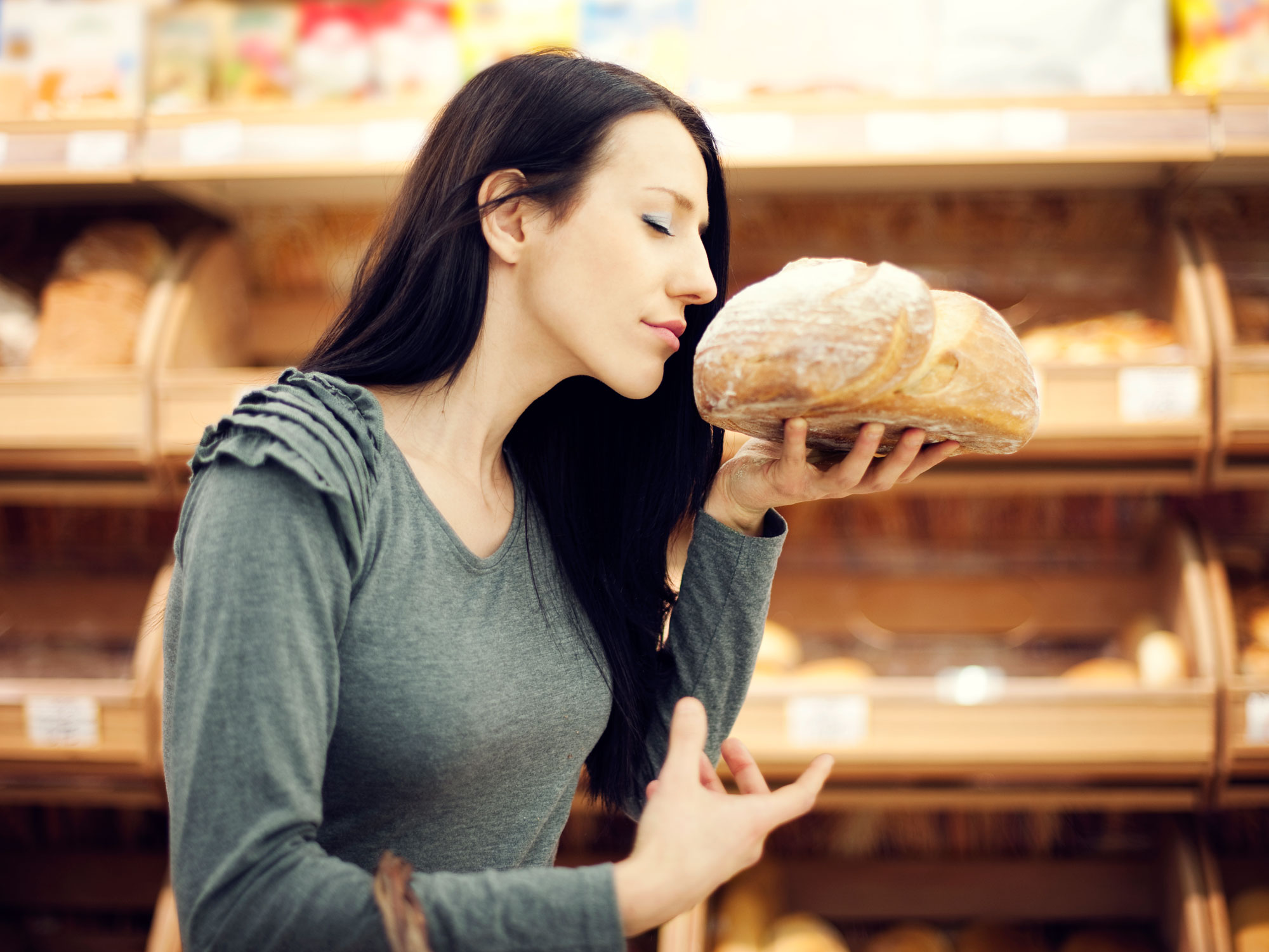 Запах голода. Девушка ест хлеб. Человек булочка. Девушка с хлебом. Девушка в магазине хлеб.