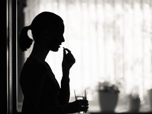 Woman taking aspirin for a migraine
